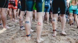 people in blue and red shorts standing on brown sand during daytime