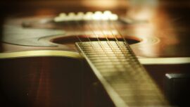 selective focus photography of wooden classical guitar